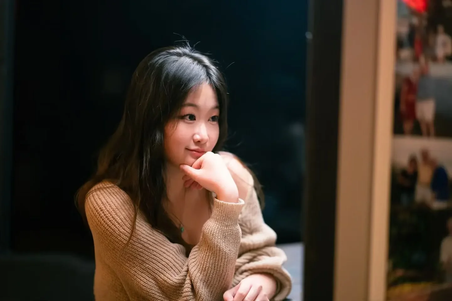 A woman resting her chin on her hand at a café table