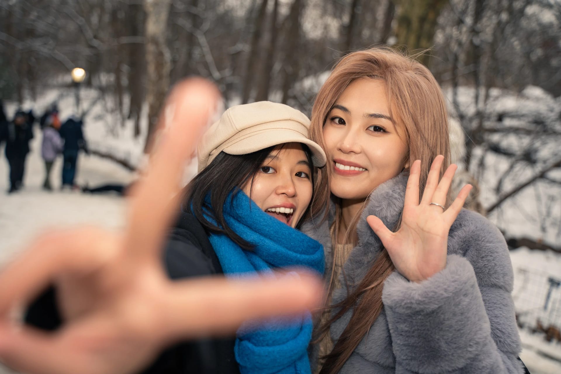 Two friends smiling with their hands raised toward the camera