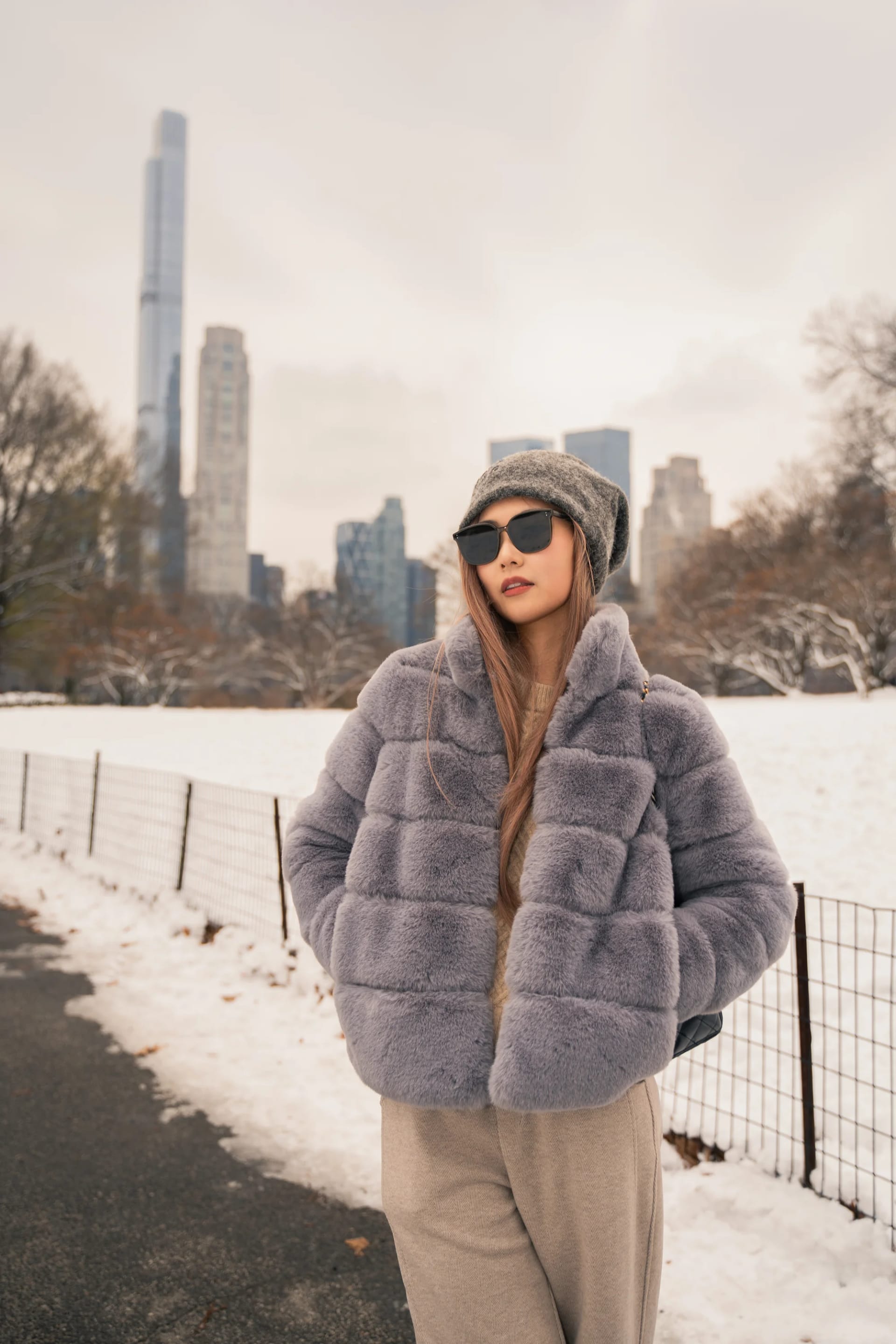A woman in sunglasses standing beside the snow-covered park