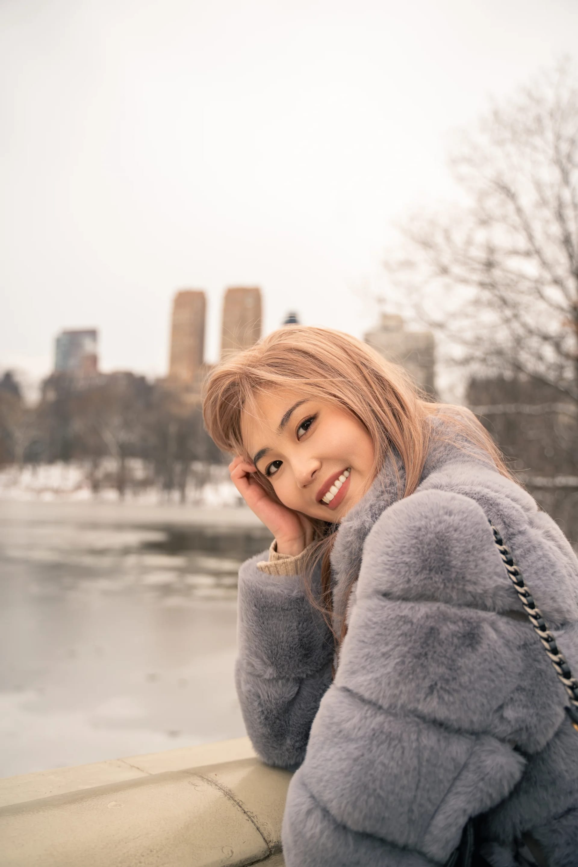 A woman resting her head on her hand above a frozen pond