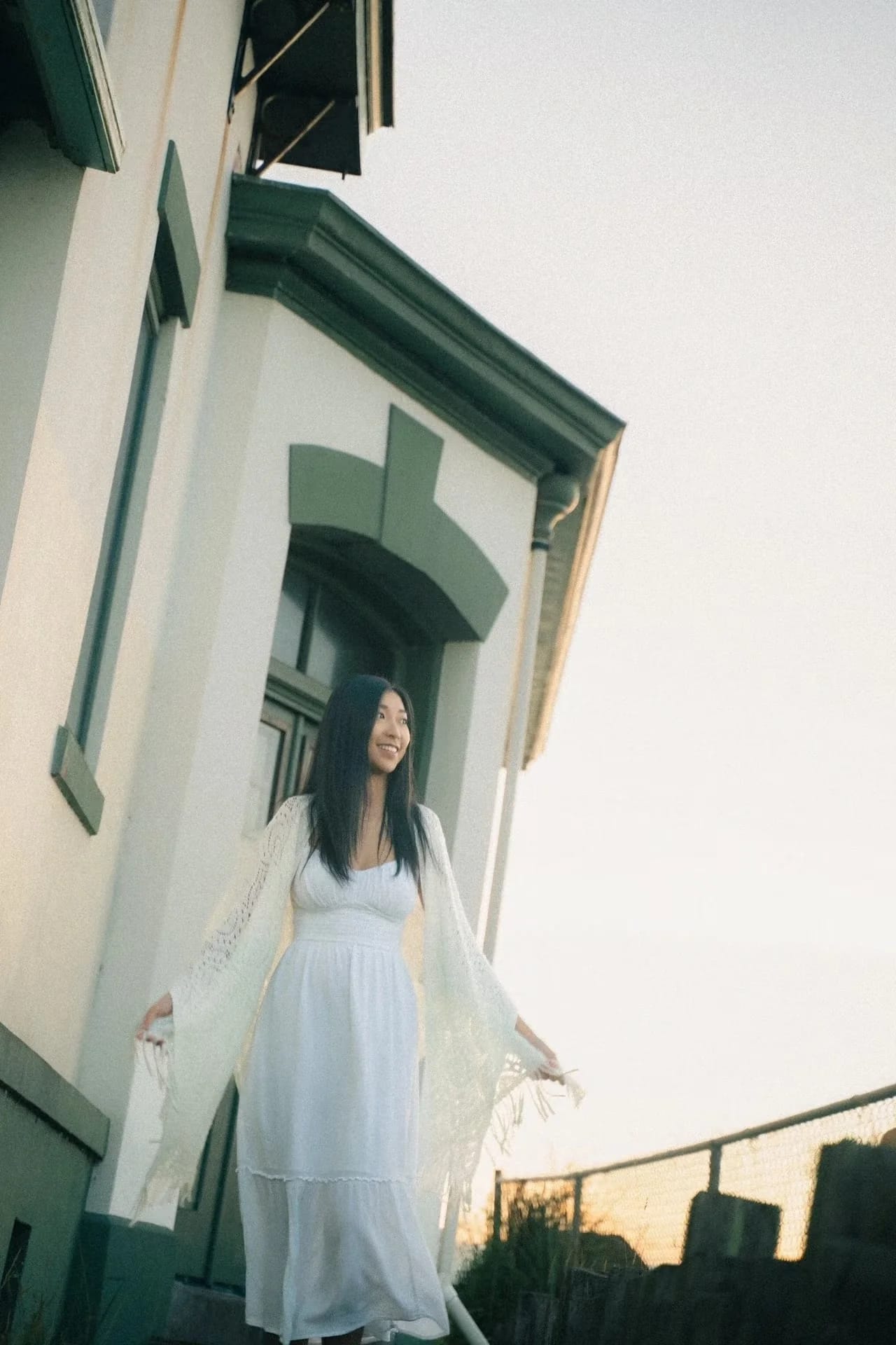 A woman in a flowing white dress framed by an open doorway