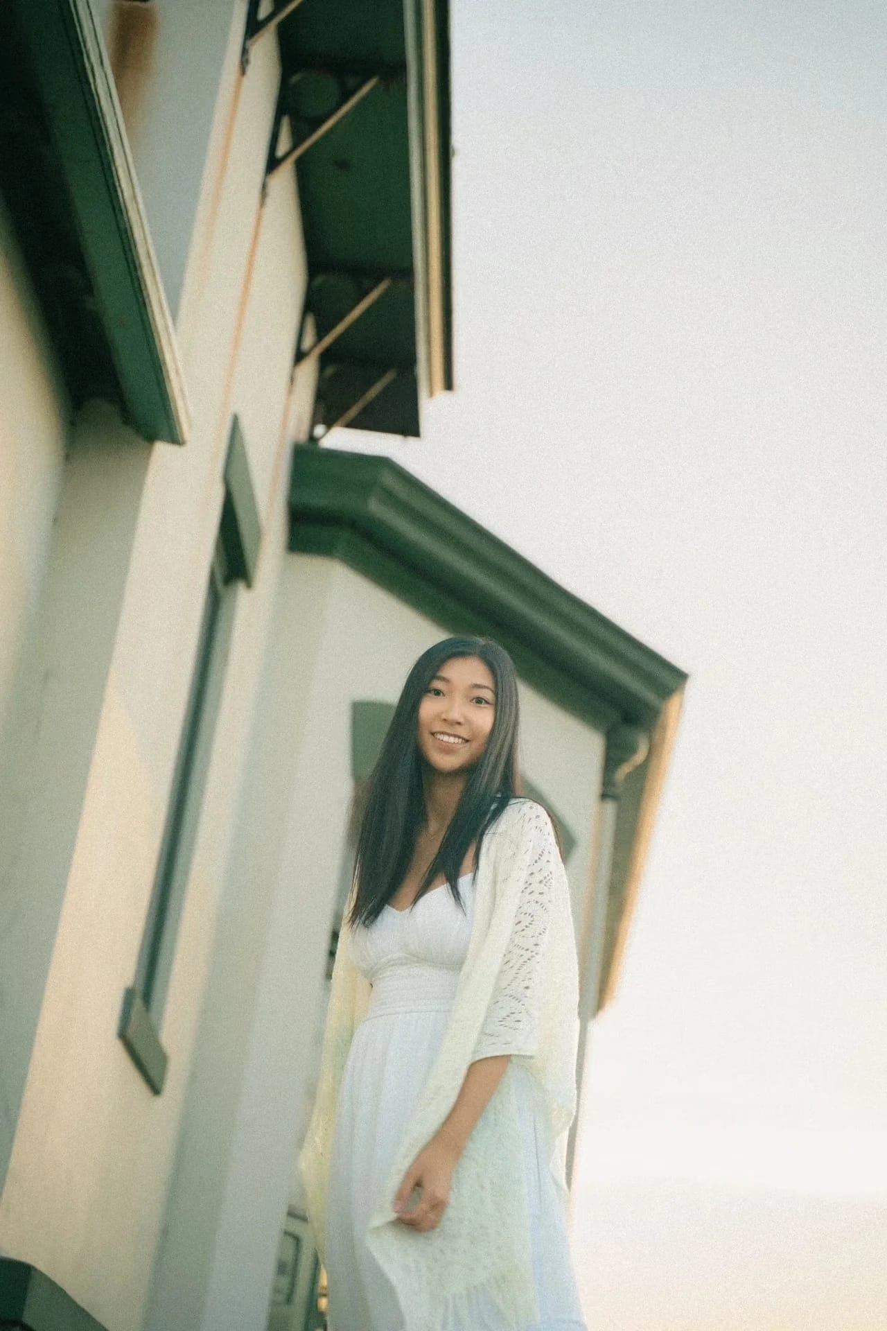 A smiling woman standing in a green-trimmed doorway