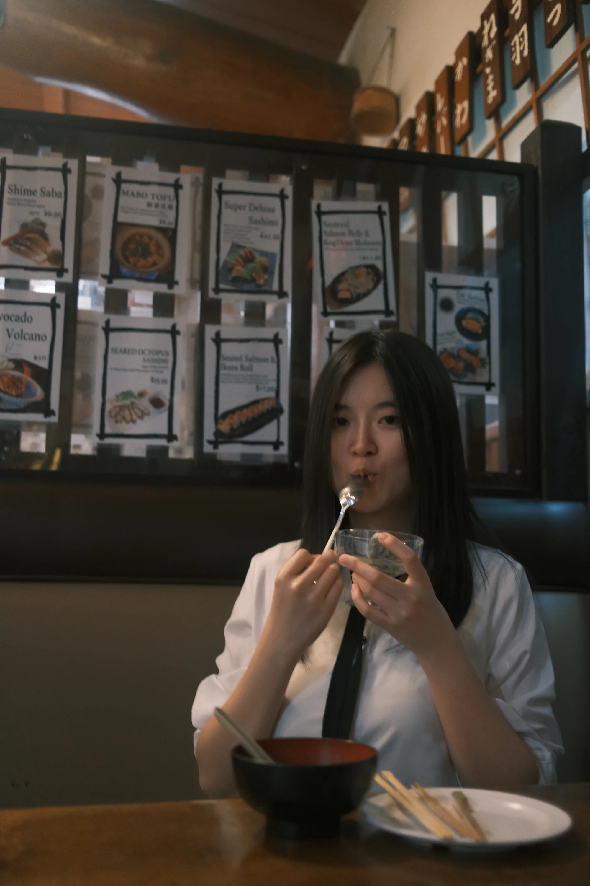 A diner holding a skewer at a dimly lit restaurant table