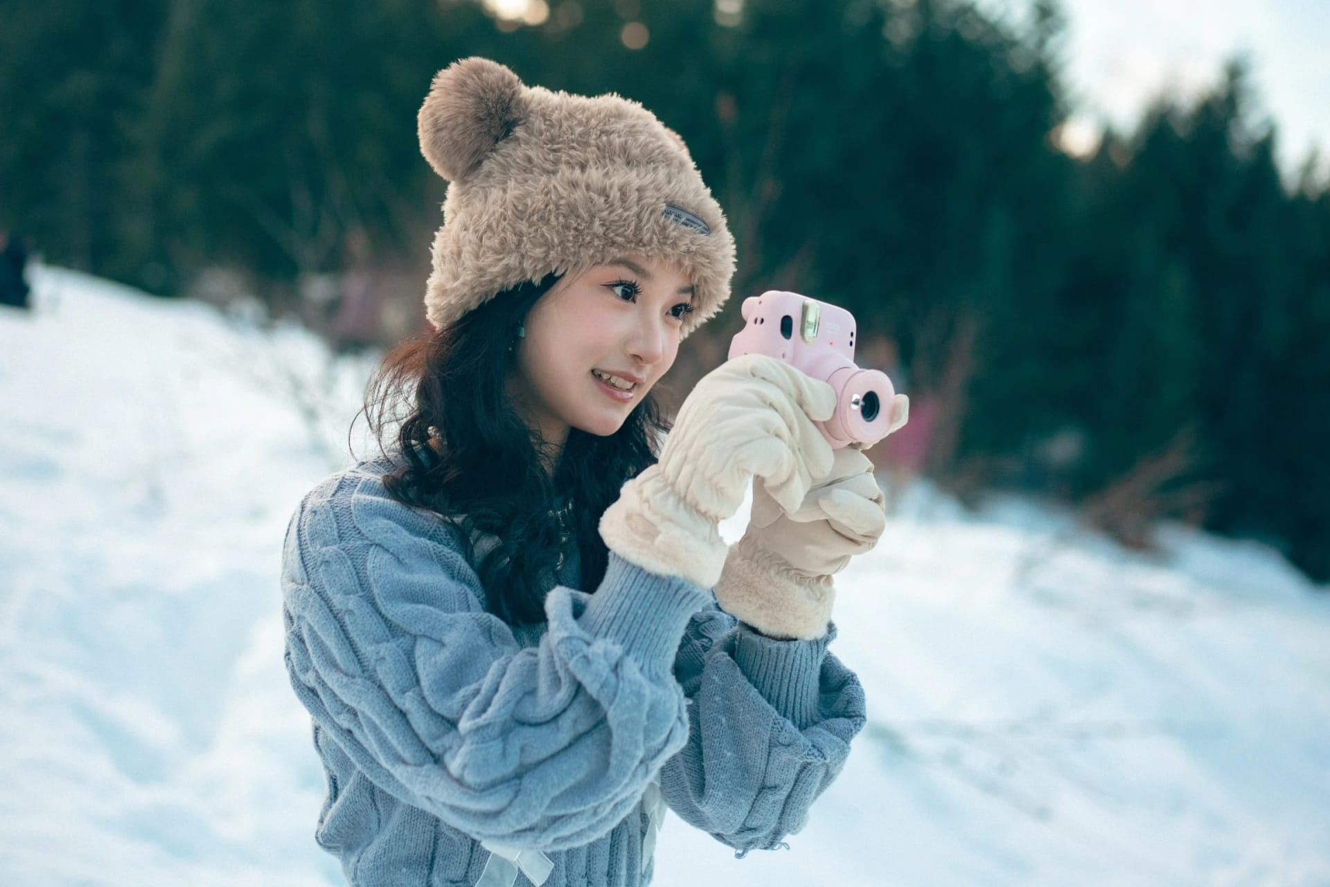 A woman looking to the side with a pink camera in gloved hands