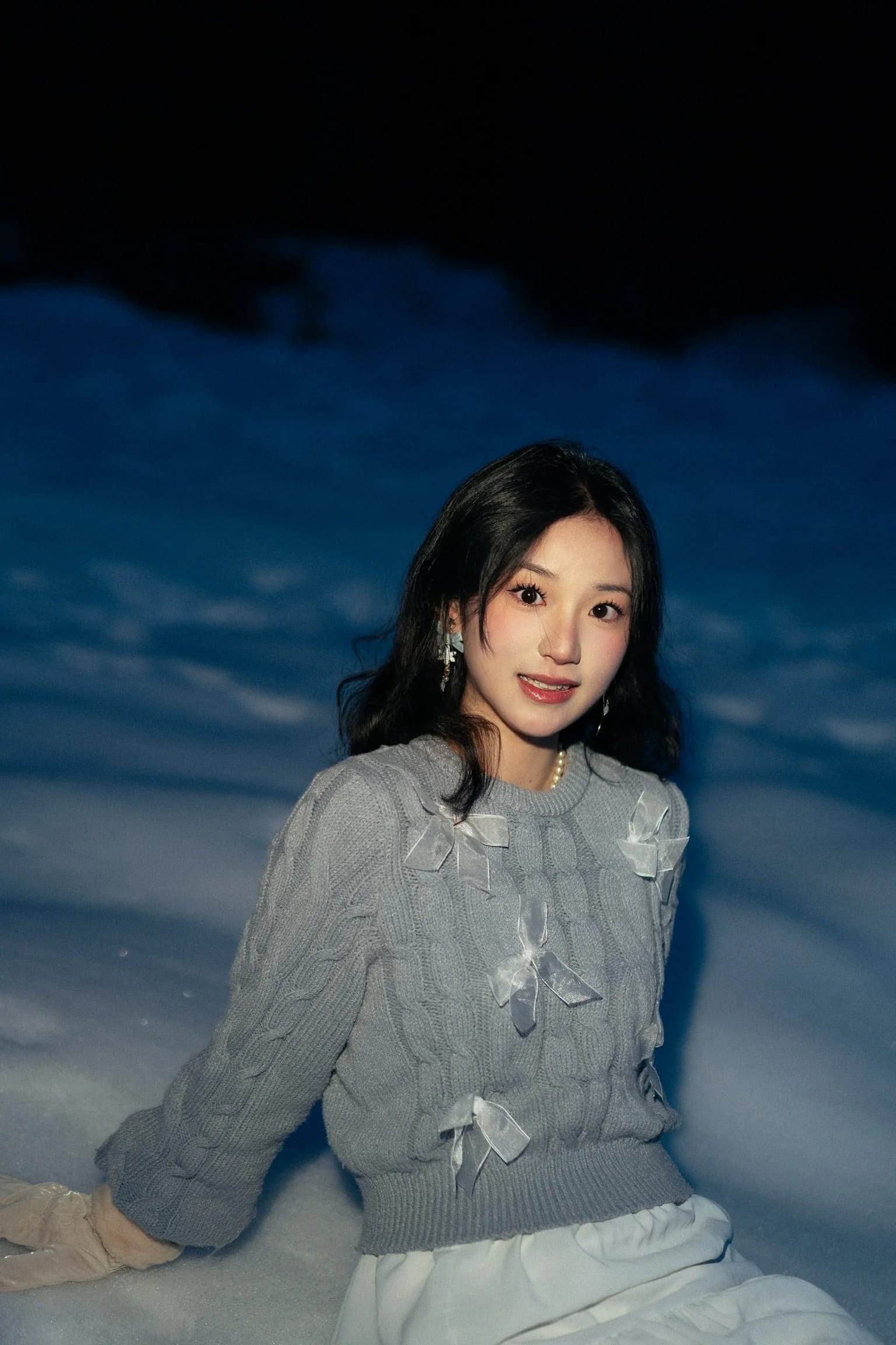 A flash-lit portrait of a woman as the snow turns blue at dusk