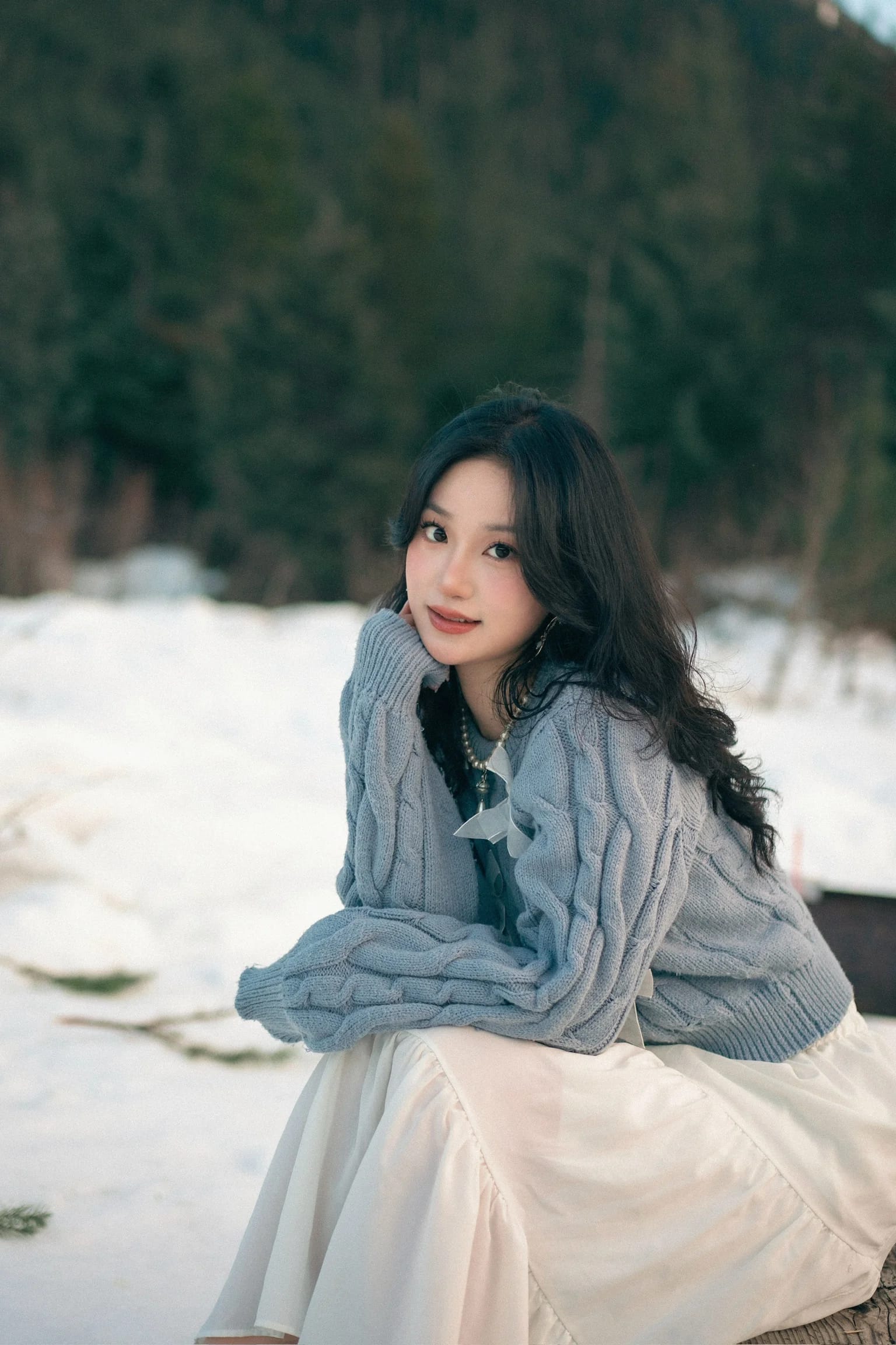 A woman looking to the side while seated at a wooden bench