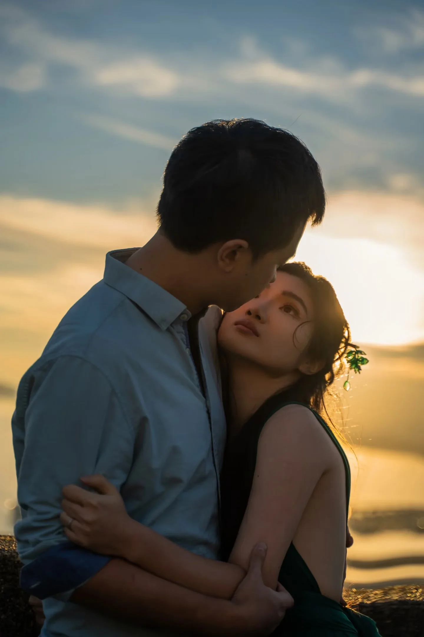 A couple embracing with the setting sun behind them