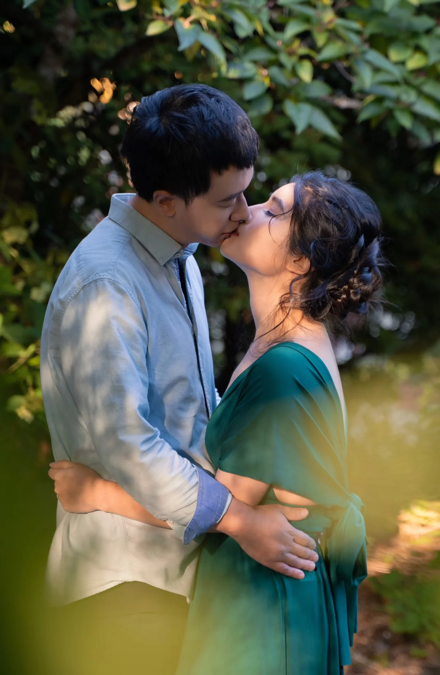 A couple kissing beside a garden bench