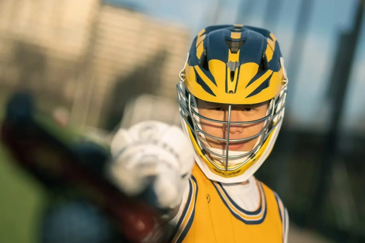 A lacrosse player reaching a gloved hand toward the camera