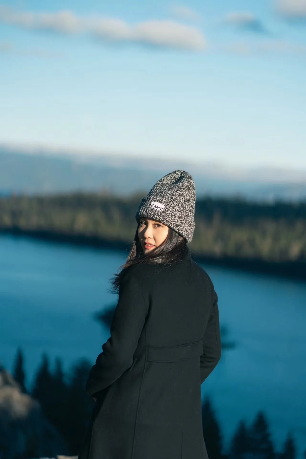 A woman looking back over her shoulder above Lake Tahoe