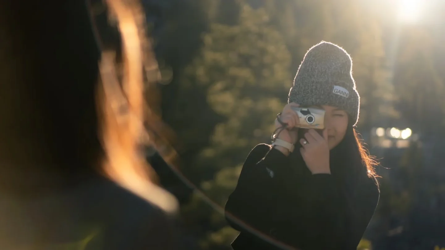 A woman photographing a friend in warm backlight